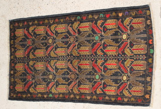 A black and green ground Tribal Belochi rug with floral decoration 55" x 32" 