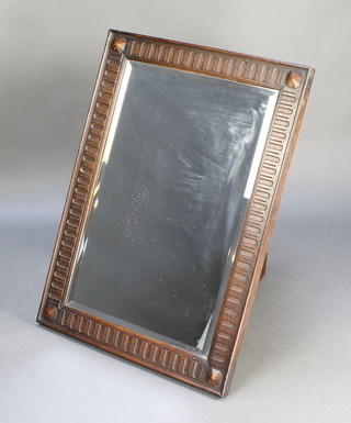 A 1930's rectangular bevelled plate wall mirror contained in an oak frame with arcaded decoration 25" x 34 1/2" 