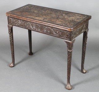 A Georgian carved oak concertina tea table, the top heavily carved a vase of flowers the apron heavily carved throughout, raised on club supports with pad feet 29"h x 34 1/2"w x 17" when closed x 34 1/2" when open 