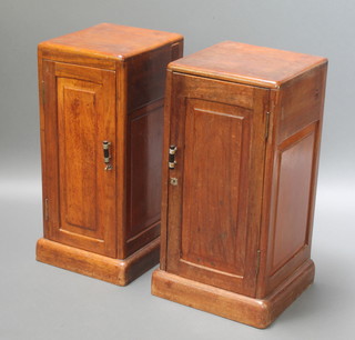 A pair of Art Deco mahogany bedside cabinets fitted cupboards enclosed by panelled doors with secret drawers to the side, raised on a platform base 31" x 13" x 15 1/2"d 