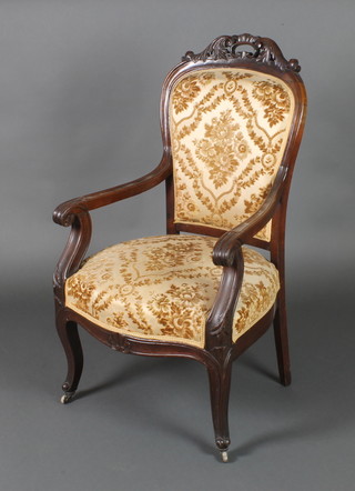 A Victorian carved mahogany open arm chair with upholstered seat and back, the seat of serpentine outline, raised on cabriole supports (some signs of old but treated worm to the base) 