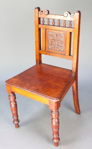 A late Victorian carved walnut hall chair with bobbin turned decoration, raised on ring turned supports 