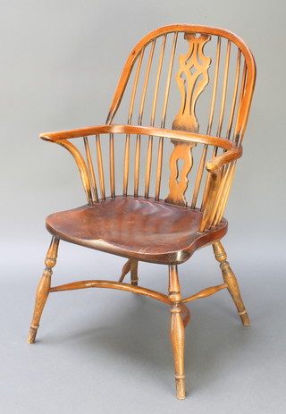 An 18th Century style elm stick back Windsor carver chair with crinoline stretcher, raised on turned supports 