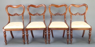 A set of 4 Victorian mahogany buckle back dining chairs with carved shaped mid rails and upholstered seats, raised on turned and reeded supports 