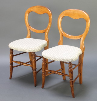 A pair of Victorian mahogany balloon back bedroom chairs with shaped seats, raised on turned supports united by turned stretchers 
