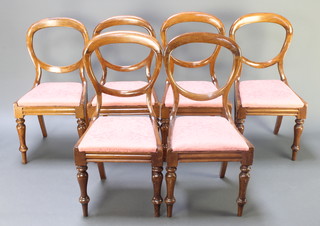 A set of 6 Victorian mahogany balloon back dining chairs with upholstered drop in seats, raised on turned supports 