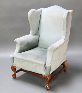 A Georgian style mahogany winged armchair upholstered in blue material, raised on cabriole supports with H framed stretcher 