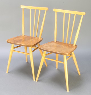 A pair of Ercol elm and beech stick and rail back dining chairs with shaped seats, raised on turned supports