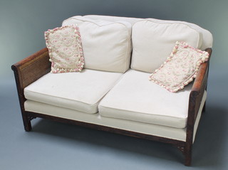 A walnut double cane bergere settee suite with blind fret decoration comprising 2 seat settee, 2 armchairs, upholstered in mushroom coloured material, sofa 30"h x 52"w x 33" 1/2d 