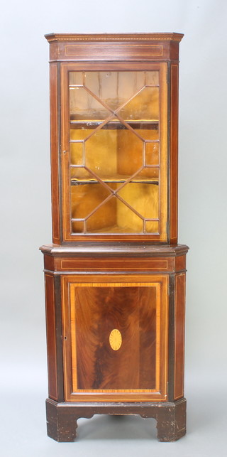 An inlaid mahogany double corner cabinet, the upper section fitted shelves enclosed by astragal glazed panelled doors, the base enclosed by a panelled door, raised on bracket feet 73"h x  26 1/2"w  