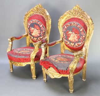 A pair of French style gilt painted plaster and carved hardwood open arm chairs with upholstered seats and backs, raised on square supports 