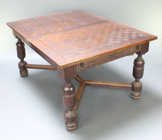 A French oak extending dining table with checkerboard inlay to the top and with 2 concealed extra leaves, raised on cup and cover supports with Y shaped stretcher 30"h x 59" when closed x 101" when extended 