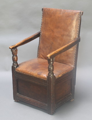 A 17th  Century oak Wainscot style chair, the seat and back upholstered in brown leather, the base on panelled construction 