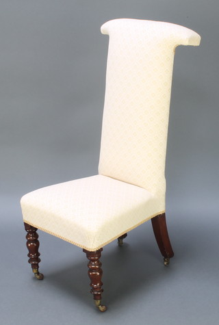 A Victorian Prie-Dieu chair upholstered in white material, raised on turned supports 