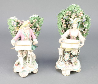 A pair of 19th Century Derby figures of a seated lady and gentleman beneath a bocage, on raised rococo bases 9" 