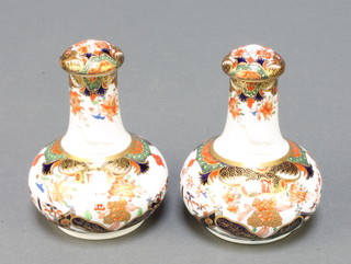 A pair of 19th Century Spode bottle vases and covers, the Imari pattern decoration with garden landscapes and moulded armorials, no. 967 4" 