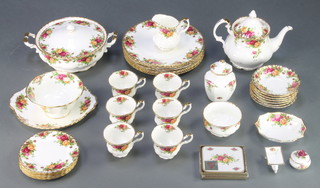 A Royal Albert Old Country Roses pattern part tea and dinner service comprising tea pot and lid, 6 tea cups, 7 saucers, milk jug, sugar bowl, slop bowl, 6 dinner plates, 1 serving plate, 6 sandwich plates, 6 coasters, a tureen and cover, a vase and cover, a dish, a wheelbarrow and a lidded box 