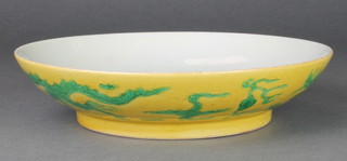 A 19th Century Chinese yellow ground shallow bowl decorated with green dragons chasing a flaming pearl, a 6 character Chia Ching mark 8 1/2" 