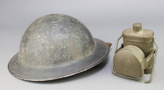 A British Steel helmet with liner together with a military issue torch with deflector 