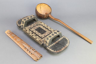 An African carved wooden breadboard 16" x 5 1/2", a wooden ladle formed from a nut and a 2 piped whistle