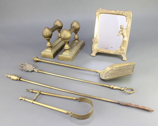 A pair of  Victorian brass railed fire dogs, a brass poker, coal shovel, pair of tongs, toasting irons and an Art Nouveau style brass easel table mirror 10" x 8" 