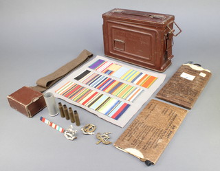 An American 30 M1 metal ammunition box, an eye shield (anti gas) Mk III, a pair of goggles, various medal ribbons, cap badges, cartridges etc  