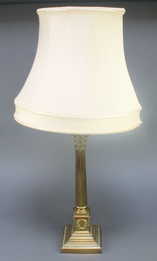 A reeded brass Corinthian column capital table lamp raised on a square stepped base 14 1/2" 