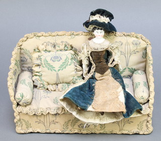 A Victorian porcelain headed doll with articulated limbs 8", together with a rectangular sofa 7" x 10" 