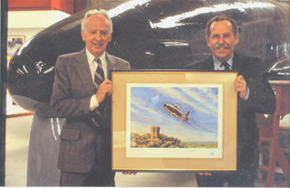 From the estate of Captain Eric M Brown a coloured photograph of Captain Eric Winkle Brown standing by a coloured print of The Gloster Whittle E28/39 with meteor in background  8" x 11 1/2" 