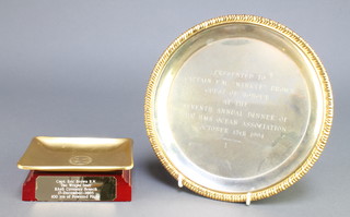 From the estate of Captain Eric M Brown a circular silver plated presentation salver engraved Presented to Captain E M "Winkle" Brown, guest of honour at the 7th Annual Dinner of HMS Ocean Association October 15th 1994 8", a rectangular gilt metal pin tray decorated the Arms of the Port of New York Authority 3" x 4 1/2" and a rectangular wooden base marked Captain E Brown The Right Stuff RAeS Coventry Branch 17th December 2003, 100 years of powered flight 