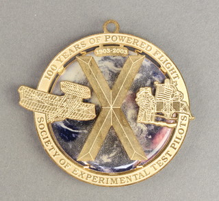 From the estate of Captain Eric M Brown a gilt metal medallion for The Society of Experimental Test Pilots 47th annual symposium and banquet celebrating 100 years of powered flight 2003 2 1/2" 


