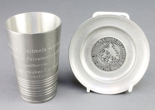 From the estate of Captain Eric M Brown a German pewter beaker with inscription together with a circular pewter pin tray 4 1/2" 