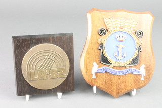 From the estate of Captain Eric M Brown an ILA 82 bronze and wooden plaque 4" x 4 1/2" and a Dutch Naval wall plaque decorated a crest 4" x 4 1/2" 