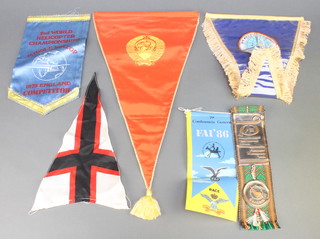 From the estate of Captain Eric M Brown, a 79 Conferencia General FIA 86 fabric pennant, a 1973 Second World Helicopter Championships Middle Wallop competitors pennant, a Fourth World Helicopter Championships pennant, a Soviet pennant marked UAK, a small black and white cross shaped pennant and a  1981 Piotrkow Trybunalski bookmark 