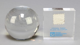 From the estate of Captain Eric M Brown a globular glass European Helicopter Association paperweight 2 1/2" together with a Sikorsky perspex paperweight containing an original section of fabric from VS-300A helicopter 