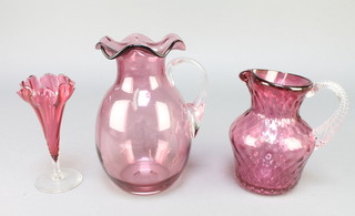 A Victorian cranberry glass jug with clear glass handle 8", a dimpled ditto 6" and a tapered vase 6" 