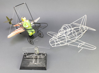 From the estate of Captain Eric M Brown a wire work model of a Gloster 328/39 aircraft 16" together with a table top model of a helicopter 6" and a humorous metal and plaster model of an aviator 