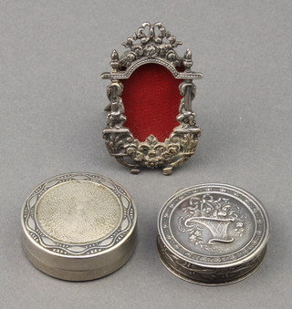 A Continental repousse silver pill box decorated with a basket of flowers 1.25", an engine turned ditto and a miniature silver frame 
