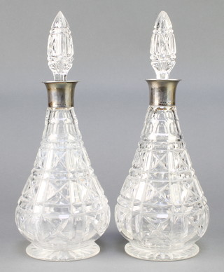 A pair of cut glass spirit decanters and stoppers with silver collars London 1928 12" 