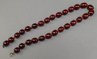 A red amber bead necklace 20" long, 50 grams