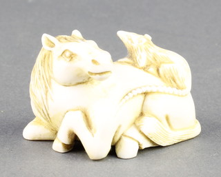 A Japanese carved ivory Netsuke in the form of a reclining horse with a rat sitting on its back, signed 1 3/4" 