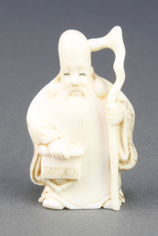 A Japanese carved ivory Netsuke in the form of a standing deity holding a scroll, signed 2" 