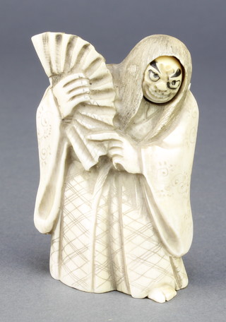 A Japanese carved stag horn Netsuke in the form of a actor with rolling face holding a fan, signed 2 3/4" 