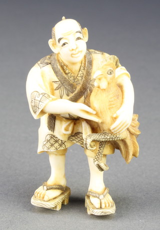 A good Japanese Meiji period carved ivory netsuke in the form of a man holding a giant cockerel, signed, 2 1/5"h