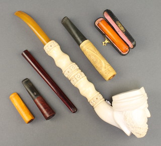 A modern carved Meerschaum pipe, the bowl in the form of a Turks head, a cigarette holder and 4 cigar holders