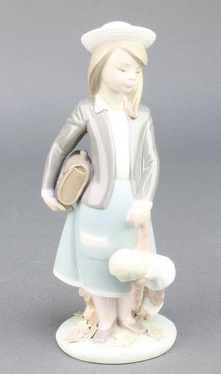 A Lladro figure of a school girl holding a doll 5218 8" 