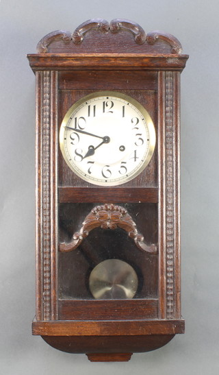 A 1930's striking wall clock with silvered dial contained in an oak case 
