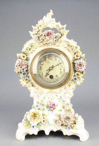 A French timepiece with silvered dial and Arabic numerals contained in a shaped porcelain and floral encrusted case 15"