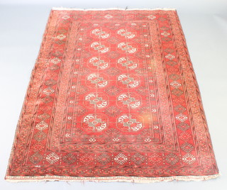 A red ground Afghan rug with 12 octagons to the centre within multi-row border 69" x 50 1/2", small hole and some wear
