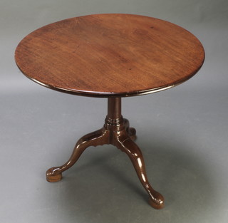 A 19th Century circular mahogany snap top tea table raised on a gun barrel and tripod base 26"h x 29" diam. 